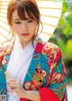 A woman in a colorful kimono holding an umbrella.