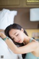 A woman laying on a bed with her eyes closed.