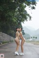 A couple of naked women standing next to each other on a road.