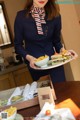 A woman holding a plate of food on a table.