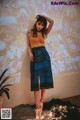 A woman standing in front of a wall covered in pictures.