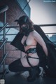 A woman wearing a mask and a black outfit.