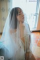 A woman in a wedding dress with a veil over her head.