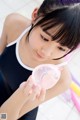 A young woman holding a pink balloon in her hand.