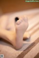 A close up of a person's bare feet on a bed.