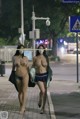 A couple of women walking down a street at night.