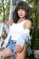 A woman sitting on top of a wooden bench.